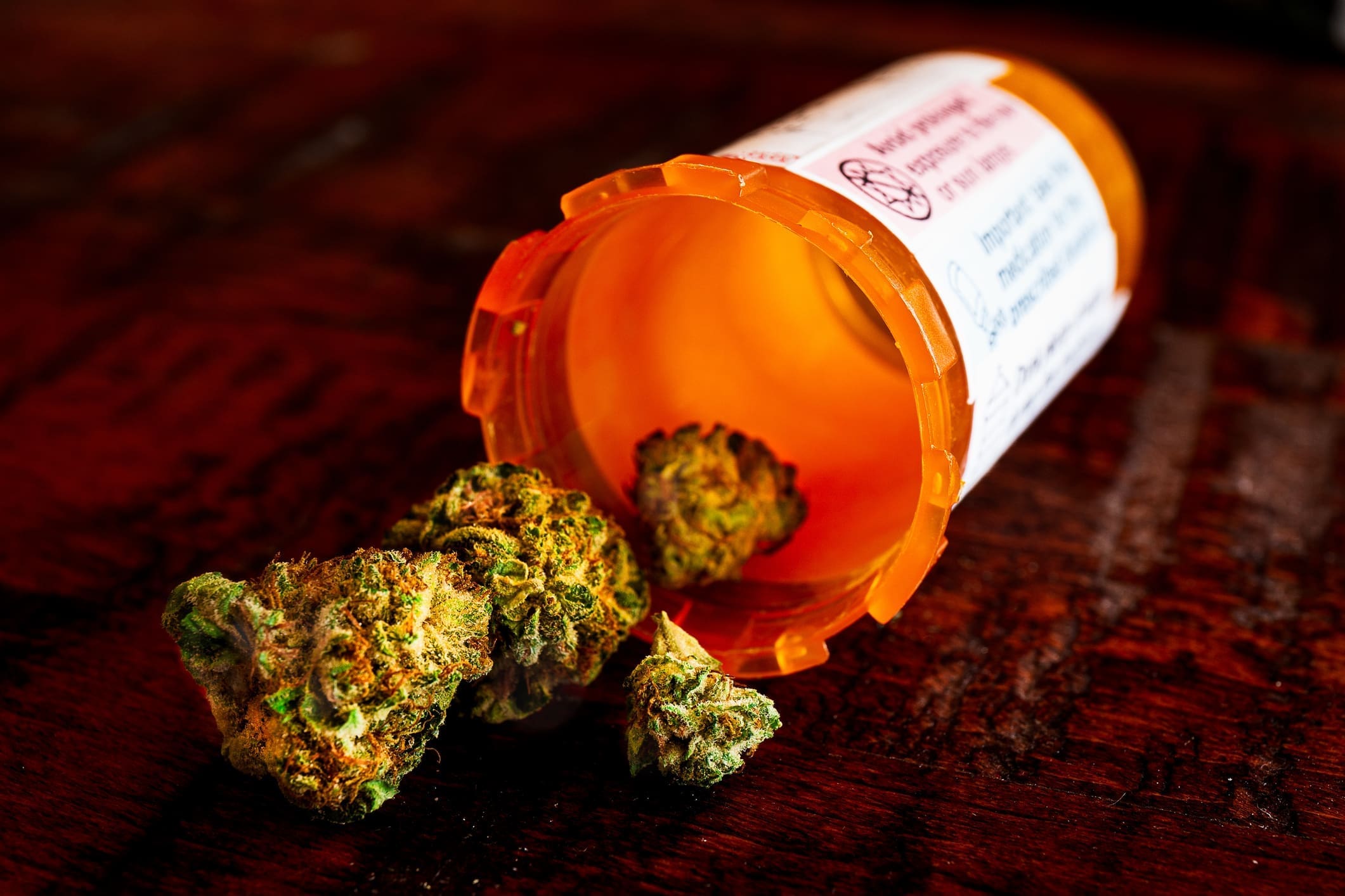 Dried Cannabis Buds Spilling Out Of Pill Bottle