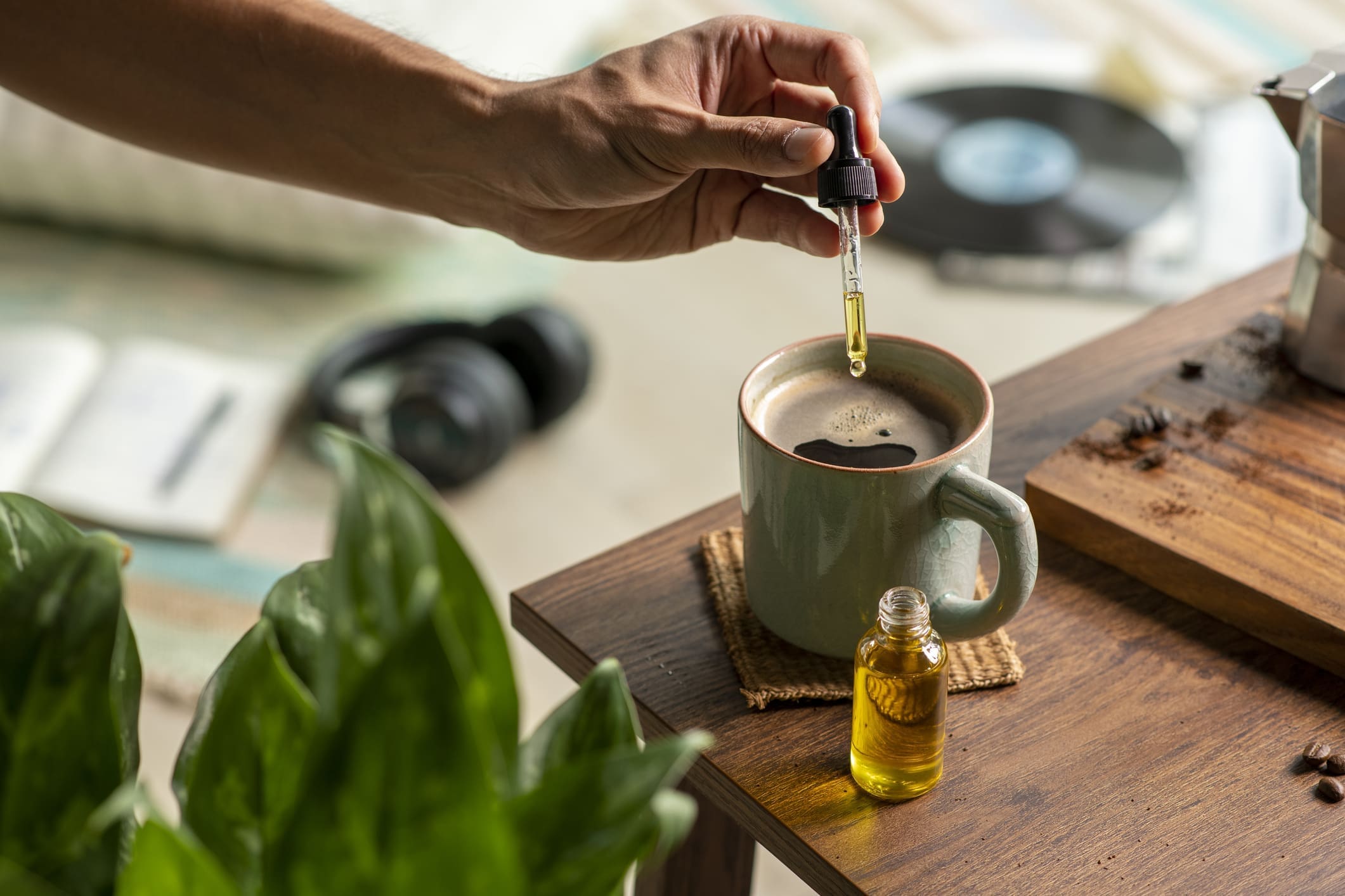 Man Dropping Cbd Oil Or Cannabis Oil Into A Coffee Cup While Relaxing At Home