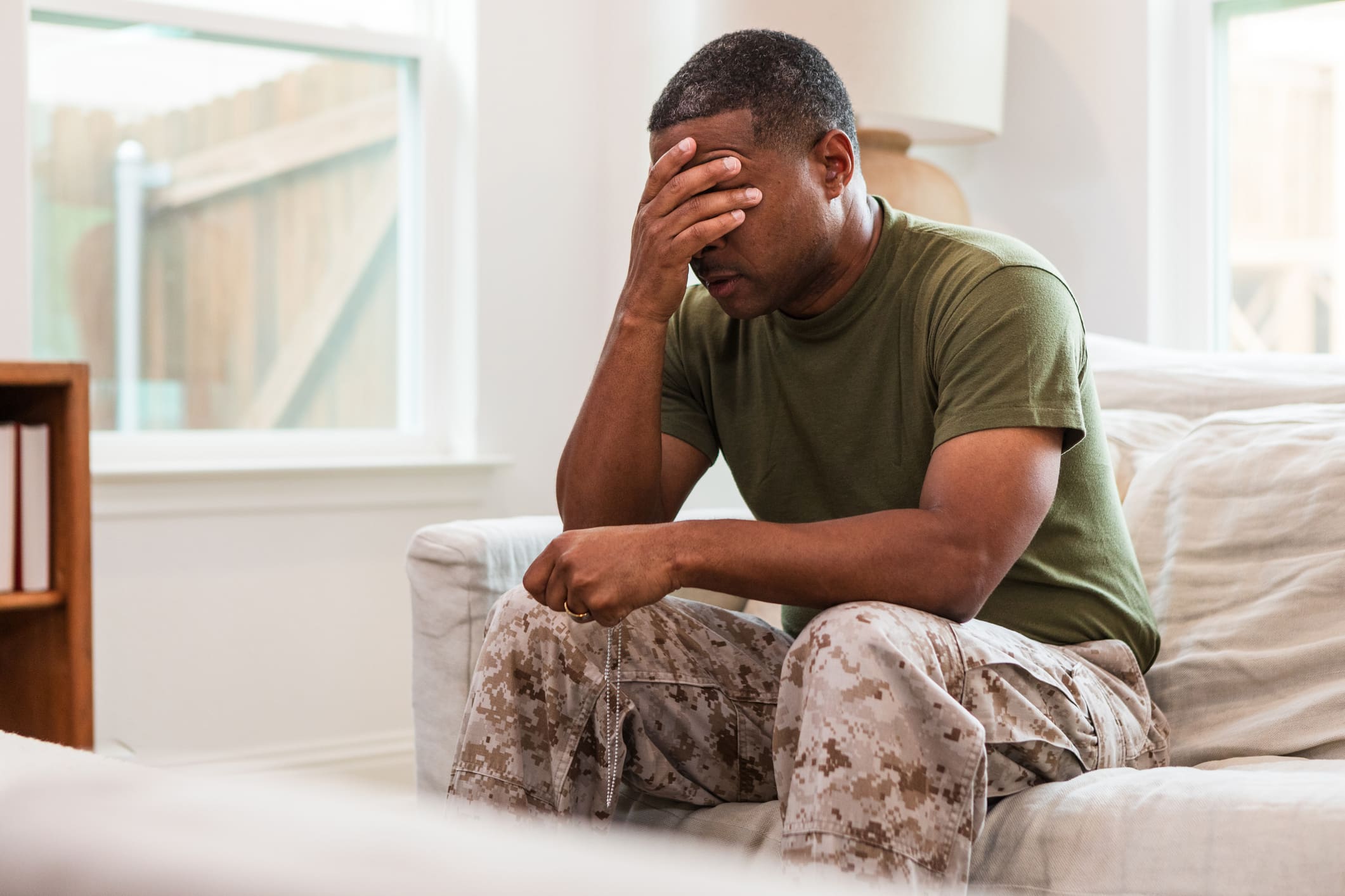 Distraught Male Soldier Sits Alone In Living Room